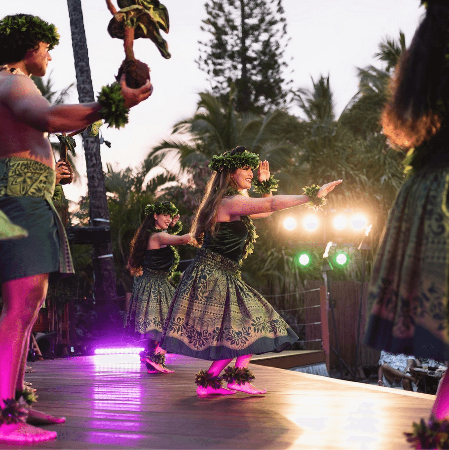 A performer dancing on the outdoor Island Breeze Luau stage