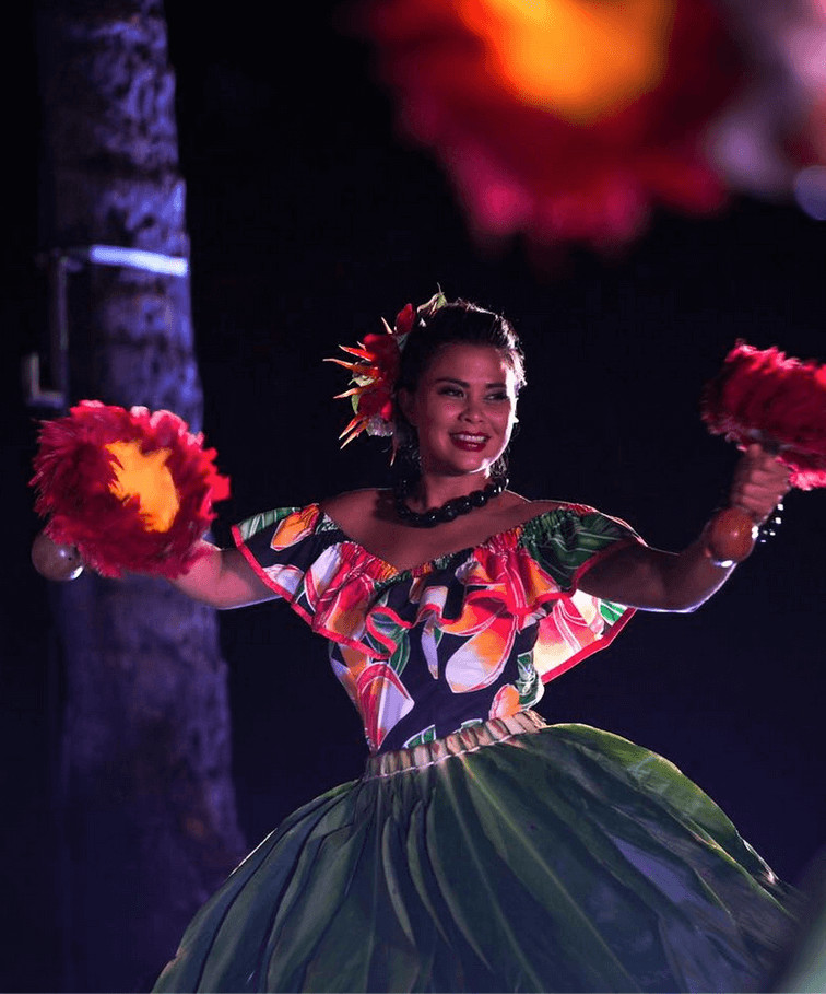 An Island Breeze Luau performer wearing a floral lei